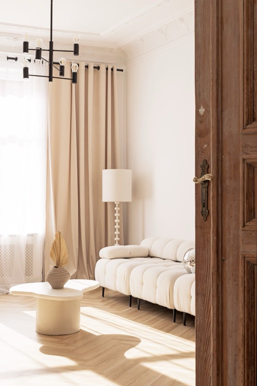 Salon Beżowy z sofą i lampą stojącą w świetle dziennym